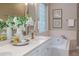 Bathroom with white cabinets and countertops, soaking tub, framed artwork, and glass block window at 2070 W Lake Hamilton Dr, Winter Haven, FL 33881