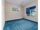 Light-filled bedroom with blue carpet, a ceiling fan, and a large window overlooking the outdoor landscape at 2070 W Lake Hamilton Dr, Winter Haven, FL 33881