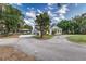 Long driveway leading to a charming home, surrounded by lush greenery and mature trees at 2070 W Lake Hamilton Dr, Winter Haven, FL 33881