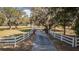 Long driveway to the property with a white fence lining the entrance, providing a sense of privacy at 2070 W Lake Hamilton Dr, Winter Haven, FL 33881