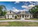 Charming single-Gathering home with a well-manicured lawn, a blue front door and a welcoming front porch at 2070 W Lake Hamilton Dr, Winter Haven, FL 33881