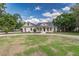 Charming single-Gathering home with a well-manicured lawn, circular driveway, and inviting blue front door at 2070 W Lake Hamilton Dr, Winter Haven, FL 33881