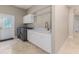 Convenient laundry room with modern washer and dryer, white cabinets, and ample counter space at 2070 W Lake Hamilton Dr, Winter Haven, FL 33881