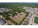 An aerial view showcases a property with outbuildings amid trees and residential homes nearby a pond at 2171 Sophia S Pl, Lakeland, FL 33811