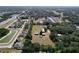 An aerial view features a large lot with several outbuildings, surrounded by homes and lush greenery at 2171 Sophia S Pl, Lakeland, FL 33811