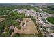 Aerial view of a house and land, highlighting its location near wooded areas and a community pond at 2171 Sophia S Pl, Lakeland, FL 33811