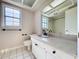 Bright bathroom with tiled floor and large counter area with a large window overlooking the front yard at 2171 Sophia S Pl, Lakeland, FL 33811