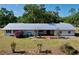 Aerial view of home featuring a long metal roof, well-maintained lawn, and tidy landscaping around patio at 2171 Sophia S Pl, Lakeland, FL 33811
