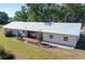 Aerial view of a white single-story home with a metal roof, lovely yard and charming garden features at 2171 Sophia S Pl, Lakeland, FL 33811