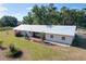 Aerial view of a white single-story home with a metal roof, lovely yard and charming garden features at 2171 Sophia S Pl, Lakeland, FL 33811