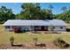 Aerial view of home featuring a long metal roof, well-maintained lawn, and tidy landscaping around patio at 2171 Sophia S Pl, Lakeland, FL 33811