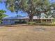 Charming single-story home featuring a metal roof, attached garage, and a large, mature shade tree in the front yard at 2171 Sophia S Pl, Lakeland, FL 33811