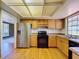 Kitchen with wooden cabinets, stainless steel refrigerator and view to second room with laminate flooring at 2171 Sophia S Pl, Lakeland, FL 33811