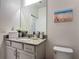 Bathroom featuring a beach themed wall art and white stone countertop sink at 2318 Rush Bay Way, Orlando, FL 32824