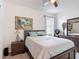 Bedroom with a bed, wood furniture and a painting hanging on the wall at 2318 Rush Bay Way, Orlando, FL 32824