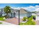 Charming single-story home features a two-car garage, brick driveway, and lush tropical landscaping at 2318 Rush Bay Way, Orlando, FL 32824