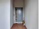 View of the front door with sidelight, brick flooring, and 