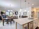 Open-concept kitchen island with white countertops and stainless steel appliances overlooking dining and living area at 2318 Rush Bay Way, Orlando, FL 32824
