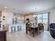 Open-concept kitchen with white cabinets, stainless steel appliances and dining area at 2318 Rush Bay Way, Orlando, FL 32824