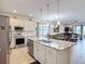 Open-concept kitchen featuring an island with stainless steel appliances and white cabinetry at 2318 Rush Bay Way, Orlando, FL 32824