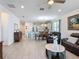 Open-concept living room with dining area and kitchen, complete with tile flooring and natural light at 2318 Rush Bay Way, Orlando, FL 32824