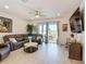 Living room with brown leather sectional, ceiling fan, sliding glass doors and lake views at 2318 Rush Bay Way, Orlando, FL 32824