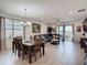 Open-concept dining room and living room with large windows and sliding glass doors with lake views at 2318 Rush Bay Way, Orlando, FL 32824