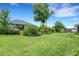 Lush backyard featuring mature trees, manicured landscaping, and a dark metal fence at 2551 Delphi Woods Cir, Lakeland, FL 33812