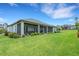 Expansive backyard with lush lawn, screened patio, and manicured landscaping at 2551 Delphi Woods Cir, Lakeland, FL 33812