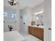 Bathroom featuring a soaking tub, a walk-in shower, wood cabinets and a large mirror at 2551 Delphi Woods Cir, Lakeland, FL 33812