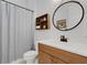 Bathroom featuring white cabinets, a large round mirror, a sink, and a shower with a curtain at 2551 Delphi Woods Cir, Lakeland, FL 33812