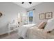 Bedroom with white bedding, a small vanity, a door leading to the bathroom, and a window at 2551 Delphi Woods Cir, Lakeland, FL 33812
