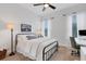 Cozy bedroom featuring a black metal bed frame, a desk with a chair, and bright windows at 2551 Delphi Woods Cir, Lakeland, FL 33812