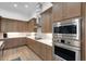 A modern kitchen featuring wood cabinets, stainless steel appliances, and white countertops at 2551 Delphi Woods Cir, Lakeland, FL 33812