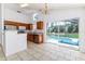 Well-lit kitchen featuring wood cabinets, stainless steel appliances, and a view of the backyard pool at 2660 Hemingway Ave, Haines City, FL 33844