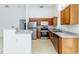 Functional kitchen featuring wood cabinetry and stainless steel appliances, perfect for cooking and entertaining at 2660 Hemingway Ave, Haines City, FL 33844
