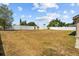 Large backyard with a white fence and scattered trees is ready for customization at 2812 Hickory Ridge Dr, Lakeland, FL 33813