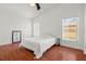 Vaulted ceiling bedroom with wood floors, two windows, and bright white walls at 2812 Hickory Ridge Dr, Lakeland, FL 33813