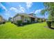 Well-maintained backyard featuring lush lawn, mature hedges, and a covered patio at 2965 Mission Lakes Dr, Lakeland, FL 33803