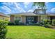 Scenic backyard view with lush grass, manicured landscaping, and inviting covered patio at 2965 Mission Lakes Dr, Lakeland, FL 33803
