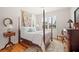 Bedroom with hardwood floors, large windows, and four-poster bed at 2965 Mission Lakes Dr, Lakeland, FL 33803