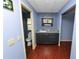 Bathroom with dark wood cabinets, granite countertops, blue walls and tile floors at 3027 Mimosa Way, Lakeland, FL 33801