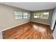 Cozy bedroom featuring hardwood floors, neutral wall colors, and bright natural light from windows at 3027 Mimosa Way, Lakeland, FL 33801