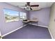 This bedroom features two large windows, a ceiling fan, and minimalist decor at 3027 Mimosa Way, Lakeland, FL 33801