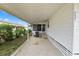 A covered carport adjacent to the home with a concrete floor and a view of the landscaped yard at 3027 Mimosa Way, Lakeland, FL 33801