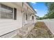 A charming front entrance with a porch and white siding, offering curb appeal at 3027 Mimosa Way, Lakeland, FL 33801