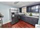 Well-equipped kitchen featuring stainless steel appliances, dark cabinets, and hardwood floors at 3027 Mimosa Way, Lakeland, FL 33801