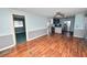Open-concept living area with hardwood floors, leading to a kitchen with stainless steel appliances at 3027 Mimosa Way, Lakeland, FL 33801