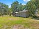A large yard with lush green grass and mature shade trees surround this cozy home at 3441 Sherertz Rd, Lakeland, FL 33810