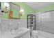 Light-green bathroom featuring tile and a shower with a glass door at 3441 Sherertz Rd, Lakeland, FL 33810
